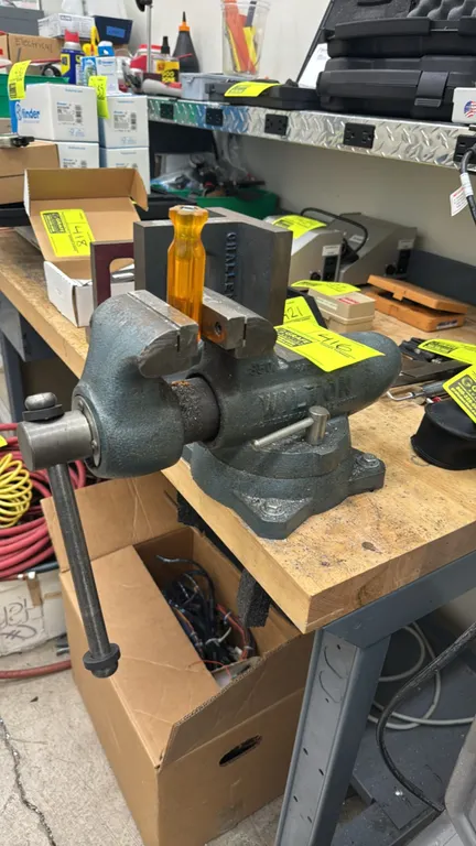 Wilton 350 bench vise. Features a swivel base with dual lockdowns, cast iron bullet-style body, and integrated anvil work surface. Screwdriver handle