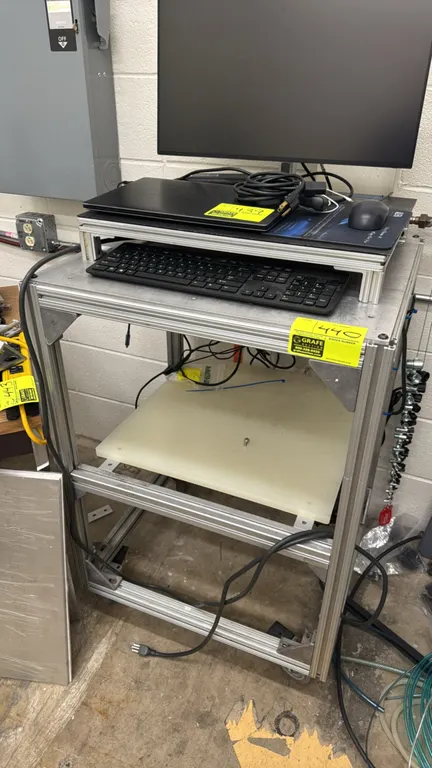 Custom aluminum portable workstation. Features extruded aluminum frame construction, upper display riser, and lower shelf. 29"L x 22"W x 40"H. Mounted