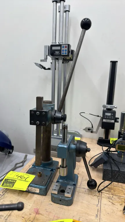 Janesville Tool & Mfg manual bench presses. Features cast metal frames, manual lever actuation, square and round rams, and slotted tooling base plates