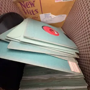 45 RPM Records With Sleeves in Brown Carrying Case