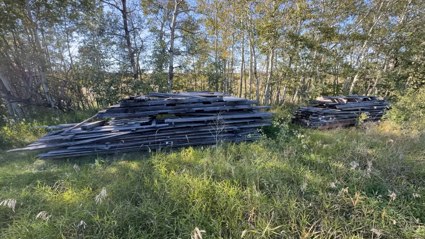 Two Large Piles of Weathered Wood Planks