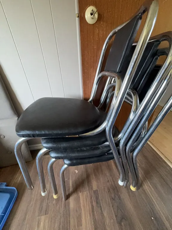 Four Black Vinyl and Chrome Stackable Chairs