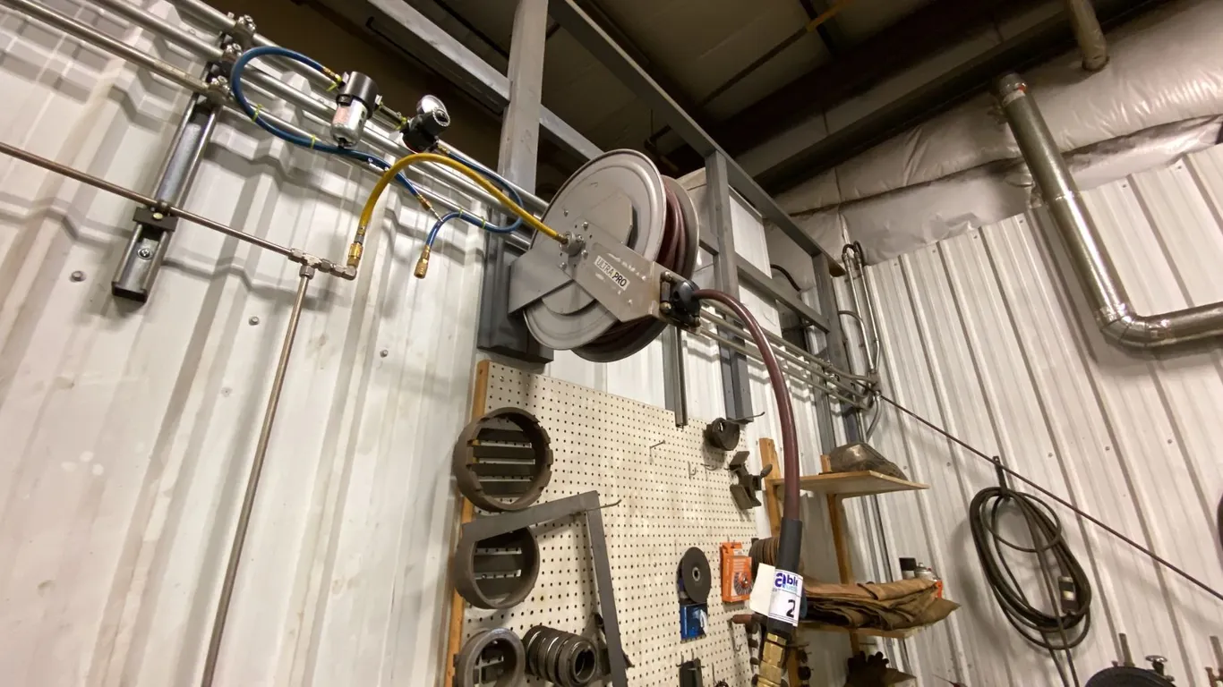 RETRACTABLE AIR HOSE REEL- APPROX 50'. BUYER TO REMOVE FROM WALL