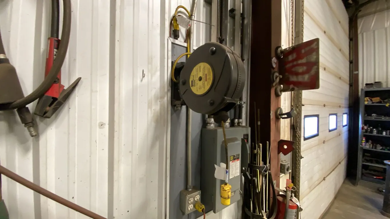 RETRACTABLE EXTENSION CORD-APPROX 50'. BUYER TO REMOVE FROM WALL