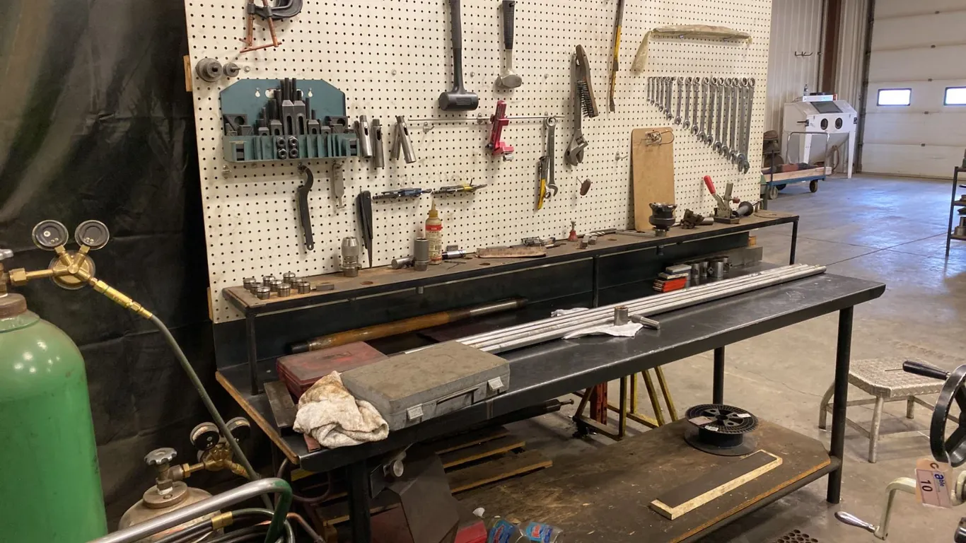8' METAL WORK BENCH. PEG BOARD BACK. INCLUDES COMBINATION WRENCH SET. HAMMERS, PRY BARS, ETC.
