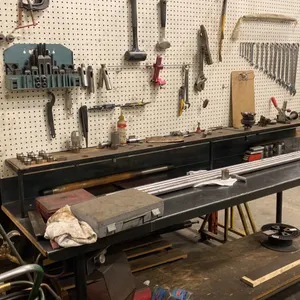 8' METAL WORK BENCH. PEG BOARD BACK. INCLUDES COMBINATION WRENCH SET. HAMMERS, PRY BARS, ETC.