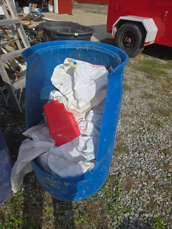 Assorted feed sacks and water barrel