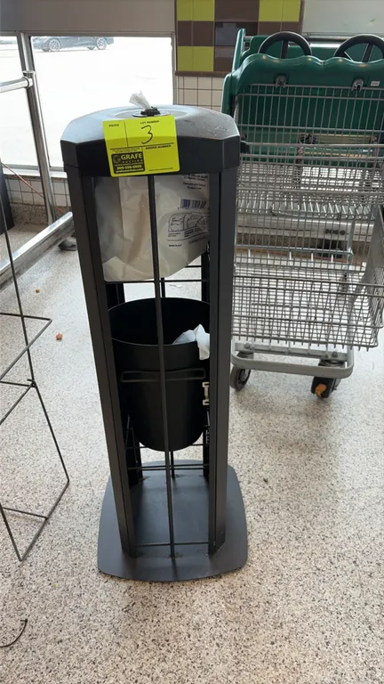 Purell sanitizing wipe dispensing station. Features top-loading wipe dispenser nozzle, integrated front waste receptacle slot, and internal trash cont