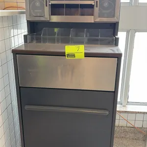 Condiment station with integrated waste receptacle. Features upper organizer hutch with clear acrylic condiment bins, utensil sorting cubbies, dual di