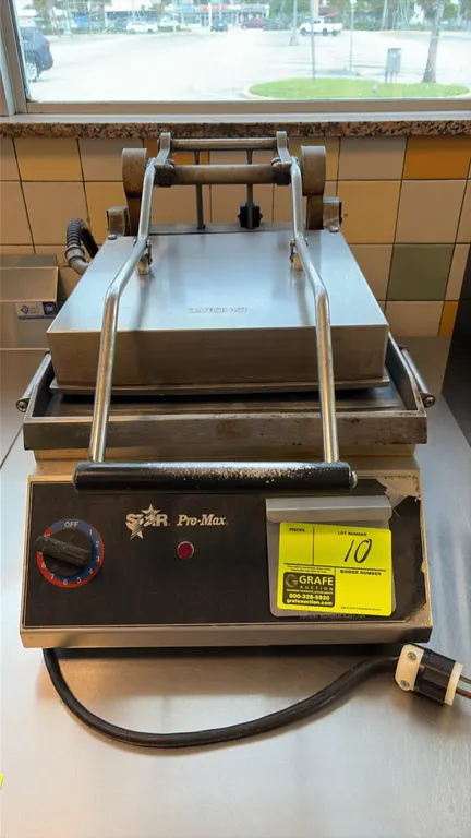 Star Pro-Max sandwich press. Features smooth flat upper and lower platens, counterbalanced top hinge mechanism, analog temperature control dial, and s