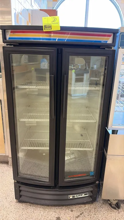 True GDM-14RF-LD reach-in beverage cooler merchandiser. Features curved double glass doors, illuminated top sign panel, adjustable wire shelving, and