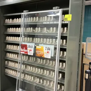 Cigarette display cabinet. Features metal frame construction, multiple shelves with spring-loaded pack pushers, top advertising display header, and sl