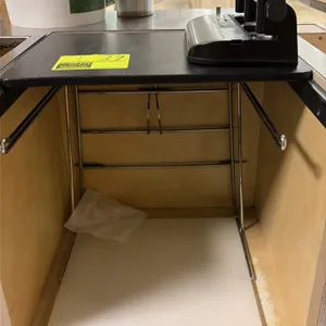 Chrome grocery bagging rack with hole punch. Includes a chrome wire bag holder with upper mounting platform and lower shelf, accompanied by a Swinglin