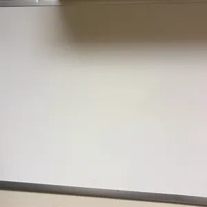 Dry-erase whiteboard. Features an aluminum frame and white writing surface. 3'L. Wall-mounted. Note: Dent along top edge of frame. Adjacent corkboard 