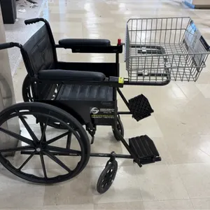 Amigo Mobility manual wheelchair. Features attached front wire shopping basket, black vinyl upholstery, padded armrests, flip-up footrests, rear mag w