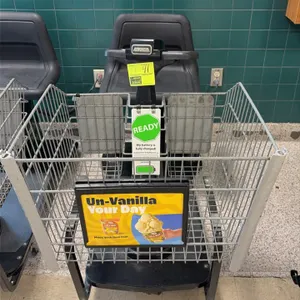 Amigo Value Shopper motorized grocery shopping cart. Features front wire basket with advertisement placard, molded plastic seat, handlebar controls, a