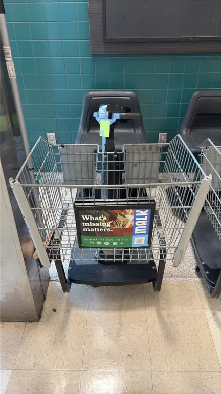 Amigo Value Shopper motorized shopping cart. Features front wire basket, molded plastic seat, steering tiller with integrated controls, and onboard ch
