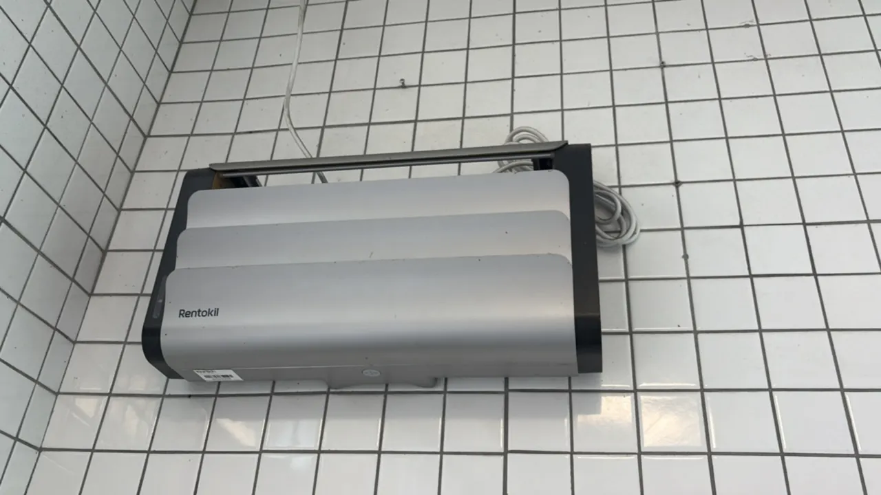 Rentokil insect light trap. Features silver-tone louvered front cover with black side panels. Designed for wall mounting. Includes attached power cord