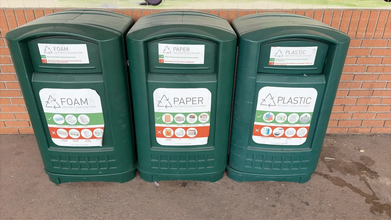 Polyethylene recycling trash cans. Features molded dark green plastic construction, front push flap waste openings, side-access service doors, and ins