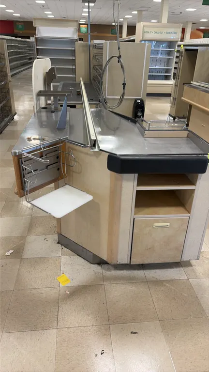 Single belt checkout lanes. Features stainless steel work surfaces, motorized conveyor belt section, bagging rack attachment, and lower storage compar