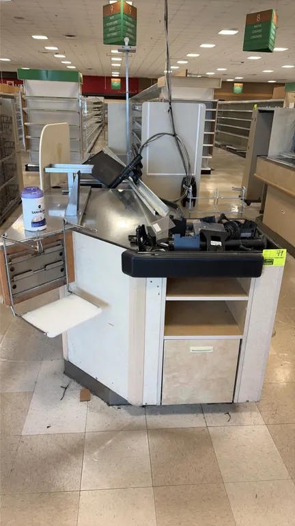 Single belt checkout lanes. Features stainless steel packing decks, bag racks, under-counter storage shelving, bumper guards, and lane divider rails.