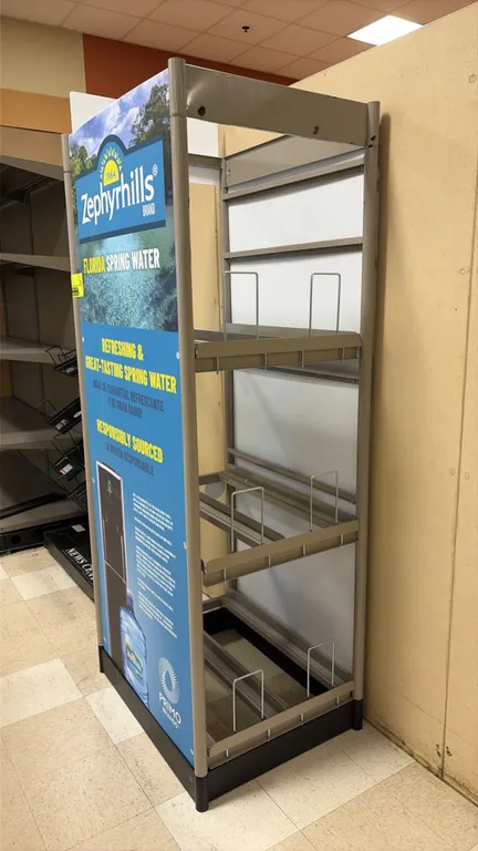 Zephyrhills branded 5-gallon bottled water display rack. Features a metal frame, 3-tier storage with bottle divider racks, and branded side and header