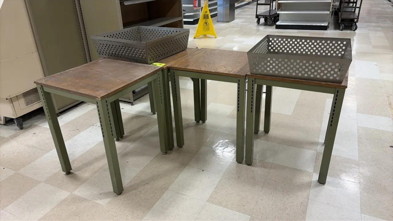 Wood laminate display tables. Features woodgrain laminate tops and green metal four-leg bases with slotted uprights and leveling feet. 24" x 24". Meta