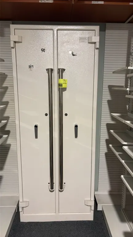 Pharmacy 2-door locking safe. Features dual hinged doors, multi-tier interior shelving, long vertical pull handles, and locking mechanism. Includes ke