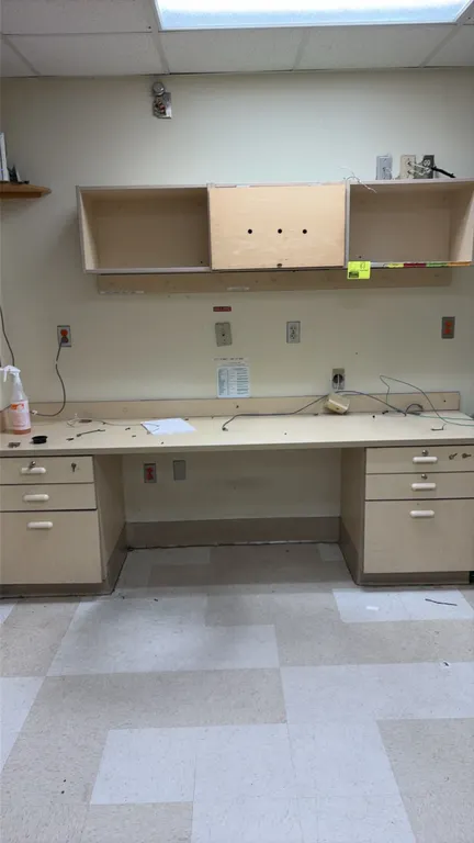Wood laminate workstation. Features a laminate work surface with integrated backsplash, two 3-drawer pedestals with white pulls, and a wall-mounted up