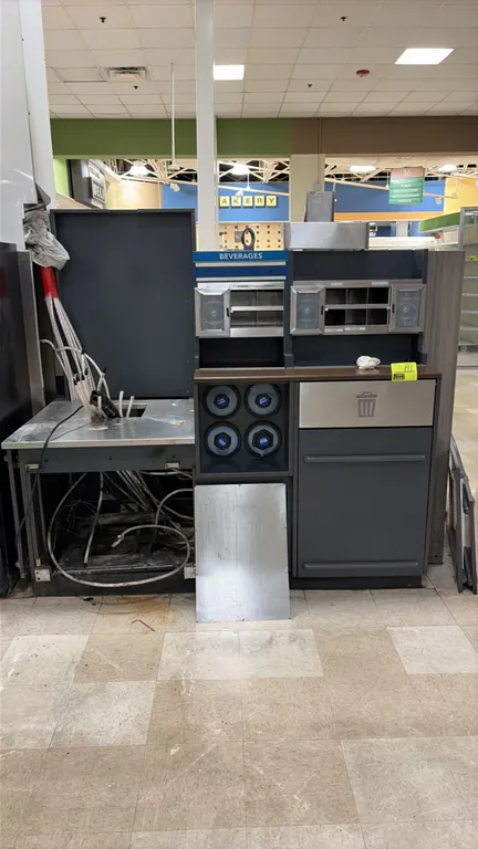 Beverage and condiment station. Features stainless steel beverage dispenser countertop, overhead condiment organizers, four cup dispensers, and integr