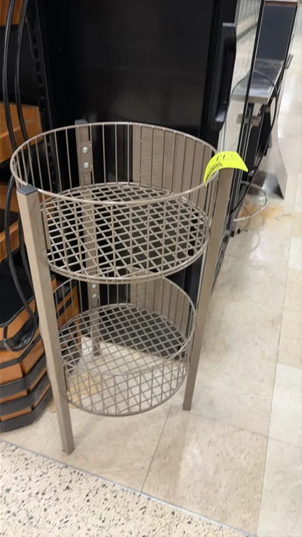 Circular 2-tier wire display basket stand. Features two round wire merchandiser baskets mounted on a 3-leg metal frame.