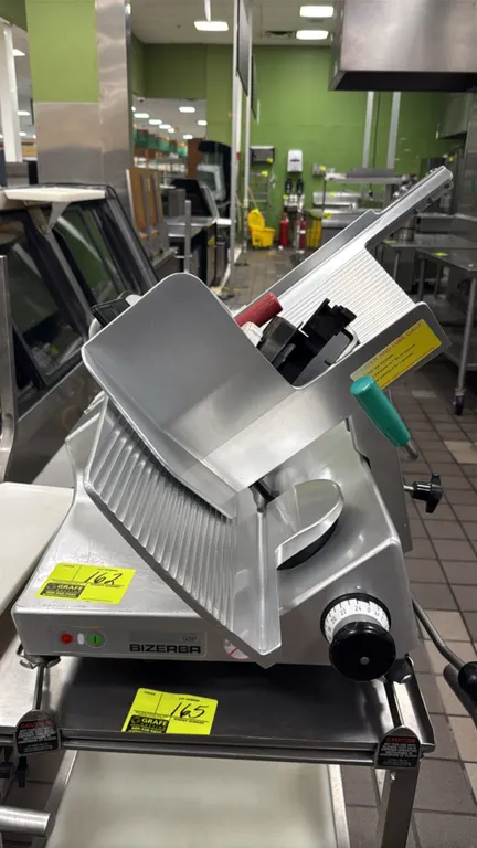 Bizerba GSP H deli slicer. Features blade sharpener, manual carriage, and adjustable slice thickness control. S/N: 11243371. Electrical: 120V, 60 Hz,