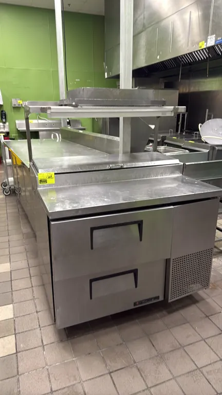 True TPP-44D-2 refrigerated 2-drawer prep table. Features stainless steel construction, 2 pull-out refrigerated drawers, raised pan rail with hinged c