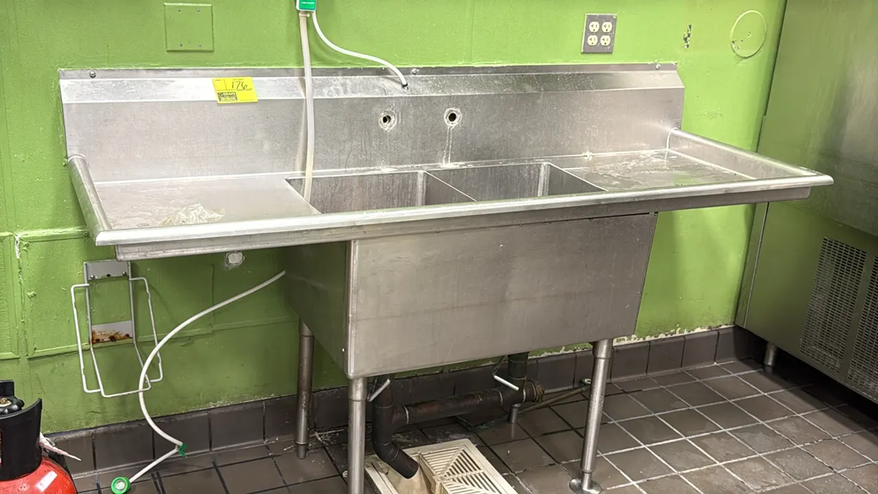 Stainless steel 2-compartment sink. Features left and right drainboards, integrated backsplash with 8" faucet drillings, rolled rim edges, and lever w