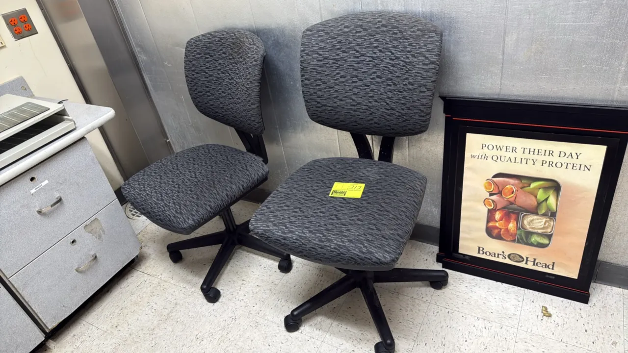 Padded rolling office task chairs. Features gray patterned fabric upholstery on padded seat and backrest, armless design, and swivel base. Mounted on