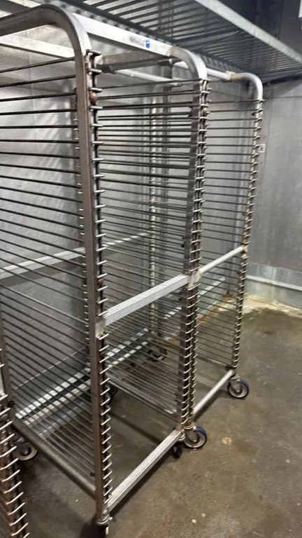 Aluminum front-load pan racks. Features welded tubular aluminum construction with multi-tier wire slides for sheet pans. Mounted on swivel casters.