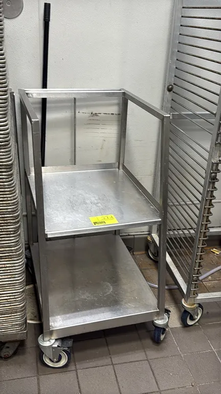 Stainless steel 2-tier sheet pan cart. Features tubular stainless steel construction, two solid shelves with raised edges, and an open top frame. Moun