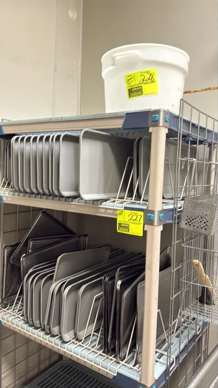 Assorted gray polymer and stainless steel trays. Features gray plastic trays and stainless steel sheet pans. Note: Shelving rack, tray dividers, and b