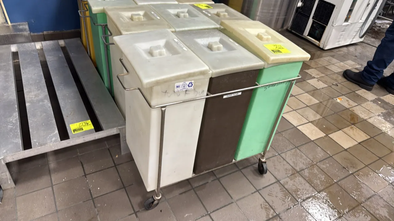 Mobile 3-bin ingredient cart. Features a tubular metal frame. Includes (3) plastic ingredient bins with removable lids in assorted colors. Mounted on