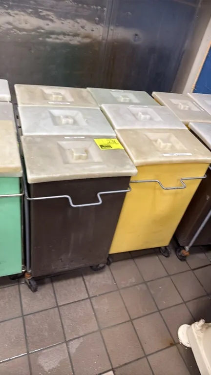 3-bin portable ingredient bins. Features tubular metal mobile frames, each holding three plastic ingredient bins with fitted lids. Mounted on swivel c