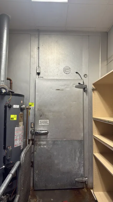Kysor walk-in freezer. Features insulated foam wall panels, diamond plate flooring, single hinged access door with kick plate, interior strip curtain,