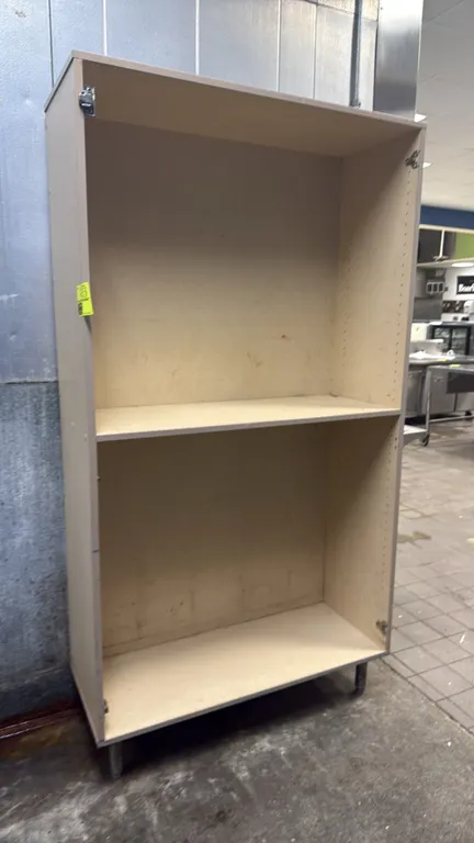 Laminate merchandiser display rack. Features two compartments, pre-drilled pin holes for adjustable shelving, and laminate finish. Mounted on metal le