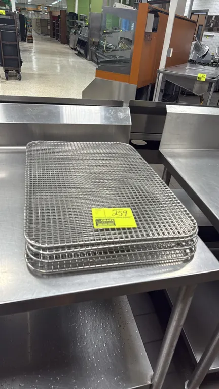 Wire cooling racks. Features wire mesh grid construction with rounded corners and raised feet. Dimensions: 16.5" x 24". Table not included.