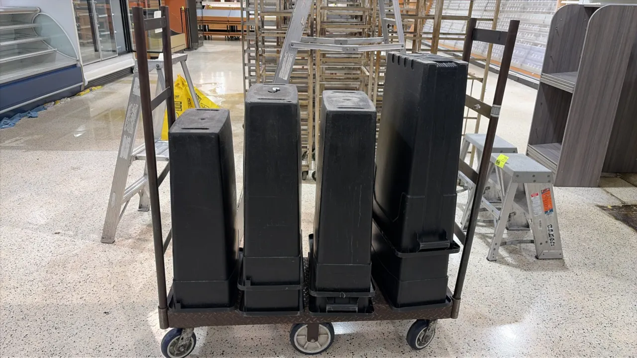 Metal 6-wheel U-boat cart with slim line trash cans. Features diamond plate steel deck and dual tubular end handles. Mounted on a 6-wheel configuratio