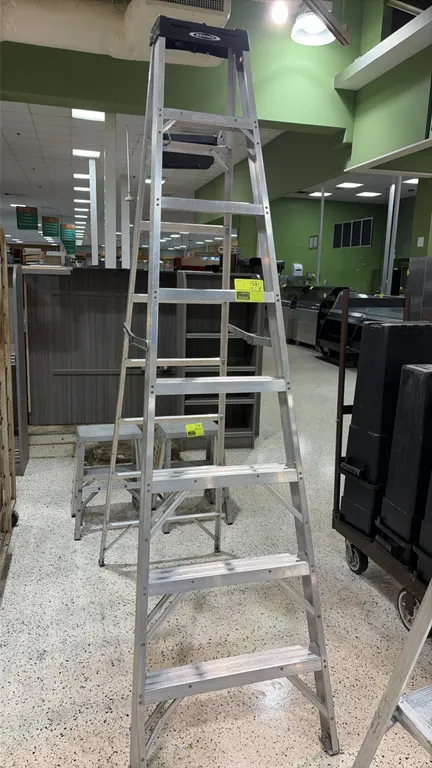 Werner 8' aluminum stepladder. Features slip-resistant grooved steps, fold-out utility tray, and molded top cap.
