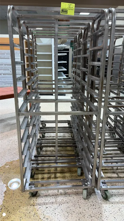 Aluminum side-load oven racks. Features aluminum tubular construction with angled sheet pan slides designed for side loading. Mounted on swivel caster