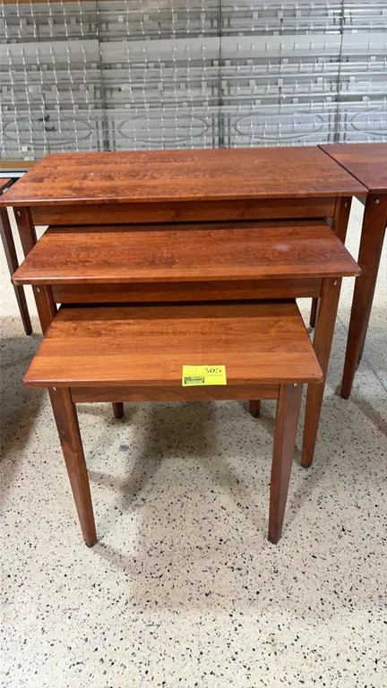 Set of (3) wood nesting tables. Features tapered square legs and a warm brown finish. Dimensions: 48"L, 36"L, and 28"L.