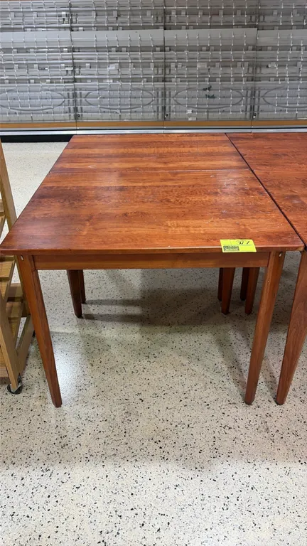 Wood bakery display tables. Features solid wood construction with a warm finish and tapered wooden legs. 38" x 30".