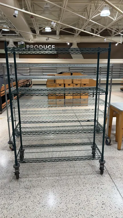 Metro portable wire shelving rack. Features (4) green epoxy-coated wire shelves. Dimensions: 48"W x 18"D. Mounted on swivel casters with donut bumpers