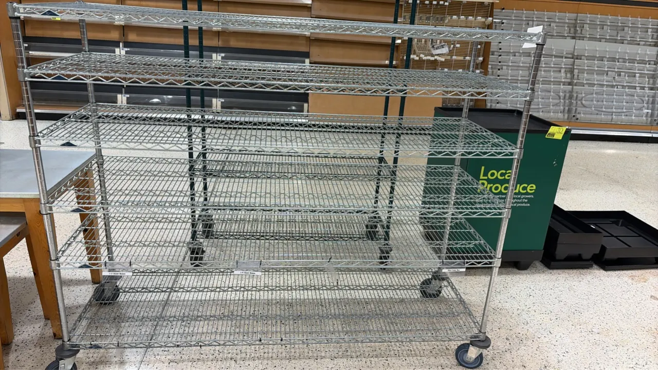 Chrome wire portable display cart. Features tiered wire shelving and shelf label clips. 60" x 24" x 60". Mounted on swivel casters with donut bumpers.